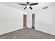 A cozy bedroom with a ceiling fan, plush carpet, and ample closet space with doors at 7214 W Crest Ln, Glendale, AZ 85310