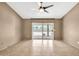 A neutral-toned bedroom with a ceiling fan, tile flooring, and a sliding glass door to the patio at 7214 W Crest Ln, Glendale, AZ 85310