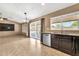 Open kitchen with granite counters, stainless dishwasher, tile floors, and slider to backyard at 7214 W Crest Ln, Glendale, AZ 85310