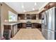 Modern kitchen with stainless appliances, dark wood cabinets, and granite countertops at 7214 W Crest Ln, Glendale, AZ 85310