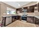 Charming kitchen with stainless steel appliances, dark cabinets, and plenty of counter space at 7214 W Crest Ln, Glendale, AZ 85310