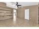 Cozy living room featuring tile floors, ceiling fan and built-in shelving at 7214 W Crest Ln, Glendale, AZ 85310