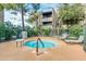 Community hot tub with lounge chairs surrounded by mature trees and a view of nearby residential buildings at 7777 E Main St # 143, Scottsdale, AZ 85251