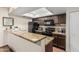 Well-lit kitchen with granite countertops, dark wood cabinetry, and black appliances at 7777 E Main St # 143, Scottsdale, AZ 85251