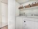 Laundry area features a white washer and dryer, and storage shelves at 7777 E Main St # 143, Scottsdale, AZ 85251