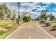 Paved community walking path winds through lush landscaping with mature trees on a bright sunny day at 7777 E Main St # 143, Scottsdale, AZ 85251