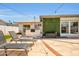 Outdoor kitchen and lounging with lush vegetation wall and patio sitting area by sliding glass door at 8614 E Rose Ln, Scottsdale, AZ 85250