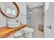 Modern bathroom with a wood countertop and a glass-enclosed walk-in shower at 8614 E Rose Ln, Scottsdale, AZ 85250
