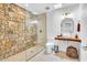 Spa-like bathroom with a stone shower and a vessel sink on a wood countertop at 8614 E Rose Ln, Scottsdale, AZ 85250