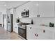 Modern kitchen featuring white cabinets, stainless steel appliances, and quartz countertops, creating a clean and efficient cooking space at 8614 E Rose Ln, Scottsdale, AZ 85250