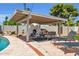 Outdoor entertaining poolside with a built-in pizza oven, covered patio and lounge chairs at 8614 E Rose Ln, Scottsdale, AZ 85250