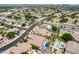 High-angle shot of a suburban neighborhood with homes featuring swimming pools and green spaces at 8738 W Runion Dr, Peoria, AZ 85382
