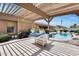 Backyard with a pool, covered pergola and lush landscaping, providing a serene outdoor retreat at 8738 W Runion Dr, Peoria, AZ 85382