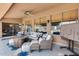 Covered patio boasts a stylish seating area, a cozy fire pit, and a view of the sparkling pool beyond at 8738 W Runion Dr, Peoria, AZ 85382
