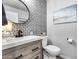 Chic bathroom showcasing a patterned tile wall, decorative mirror, and sleek vanity at 8738 W Runion Dr, Peoria, AZ 85382