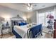 Comfortable bedroom featuring a wrought iron bed, plush bedding, and a ceiling fan at 8738 W Runion Dr, Peoria, AZ 85382