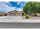 Charming single-story home featuring a three-car garage, desert landscaping, and mature shade tree at 8738 W Runion Dr, Peoria, AZ 85382