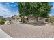 Charming single-story home featuring a well-manicured xeriscaped front yard and a mature shade tree at 8738 W Runion Dr, Peoria, AZ 85382