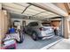 Spacious three-car garage with an epoxy floor and ample storage, featuring a modern SUV at 8738 W Runion Dr, Peoria, AZ 85382