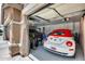 Three-car garage with epoxy flooring, a car, a convertible, and extra storage space at 8738 W Runion Dr, Peoria, AZ 85382