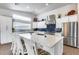This is a kitchen with an island, stainless steel appliances, and blue backsplash at 8738 W Runion Dr, Peoria, AZ 85382