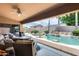 Backyard featuring a covered patio with wicker furniture and a beautiful pool with a waterfall feature at 8738 W Runion Dr, Peoria, AZ 85382