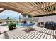 Backyard includes covered pergola, barbecue grill and a freeform pool with lush landscaping at 8738 W Runion Dr, Peoria, AZ 85382