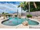 Sparkling pool with rock features and lush greenery create a serene backyard oasis for relaxation at 8738 W Runion Dr, Peoria, AZ 85382