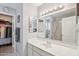 Bright bathroom with a walk-in closet, white vanity, and large mirrors over the sink at 10521 W Ross Ave, Peoria, AZ 85382