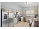 Well-lit kitchen features stainless steel appliances, tile floors, and decorative wood cabinets at 10521 W Ross Ave, Peoria, AZ 85382