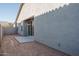 Spacious backyard showcasing the exterior of the home with a sliding glass door and a concrete patio at 1057 S 151St Ln, Goodyear, AZ 85338
