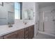 Bathroom featuring a double vanity, dual mirrors, and walk-in shower at 1057 S 151St Ln, Goodyear, AZ 85338