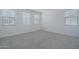 A minimalistic bedroom with three windows, neutral colors, and carpeting at 1057 S 151St Ln, Goodyear, AZ 85338