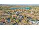 An aerial view of community homes nestled around a large lake with mountain views at 11255 S San Adrian Ln, Goodyear, AZ 85338