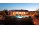 Home exterior featuring a sparkling pool, solar panels, and desert landscaping at 11255 S San Adrian Ln, Goodyear, AZ 85338
