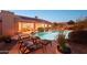 Outdoor seating area by the pool with solar panels on the roof of the house at 11255 S San Adrian Ln, Goodyear, AZ 85338