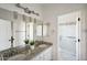 Bright bathroom featuring dual sinks, white cabinets, and a glass-enclosed shower at 11255 S San Adrian Ln, Goodyear, AZ 85338