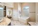 Bright bathroom featuring a soaking tub and granite-topped vanity at 11255 S San Adrian Ln, Goodyear, AZ 85338