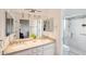 Bright bathroom with double sinks, granite countertops, a large mirror, and a walk-in shower at 11255 S San Adrian Ln, Goodyear, AZ 85338