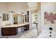 Bright bathroom featuring a vanity with granite countertop and dark wood cabinets with view into the home at 11255 S San Adrian Ln, Goodyear, AZ 85338
