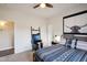 Comfortable bedroom with ceiling fan, queen bed, modern furnishings and carpet floors at 11255 S San Adrian Ln, Goodyear, AZ 85338