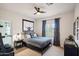Comfortable bedroom with ceiling fan, queen bed, modern furnishings and carpet floors at 11255 S San Adrian Ln, Goodyear, AZ 85338