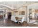 Elegant dining area with wood floors, decorative light fixture, and seamless flow to the living room and kitchen at 11255 S San Adrian Ln, Goodyear, AZ 85338