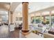 Bright open-concept living space featuring large windows, decorative pillars, and seamless flow to the dining area at 11255 S San Adrian Ln, Goodyear, AZ 85338