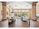 Spacious open-concept living and dining area featuring wood floors and abundant natural light from large windows at 11255 S San Adrian Ln, Goodyear, AZ 85338