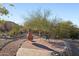 Outdoor patio with a dining table and chairs, surrounded by desert landscaping at 11255 S San Adrian Ln, Goodyear, AZ 85338