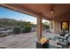 Cozy covered patio with a fire pit, stone flooring, and views of the lush backyard and pool at 11255 S San Adrian Ln, Goodyear, AZ 85338