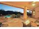 Covered patio with a fire pit and views of the pool and desert landscape at 11255 S San Adrian Ln, Goodyear, AZ 85338