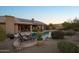 Inviting backyard pool featuring desert landscaping, stone accents, and a covered patio area for relaxation at 11255 S San Adrian Ln, Goodyear, AZ 85338