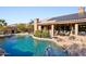 Large pool surrounded by a stone patio, with solar panels visible on the home's roof at 11255 S San Adrian Ln, Goodyear, AZ 85338